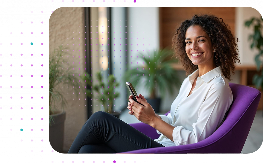 Smiling woman sitting with phone in hand.
